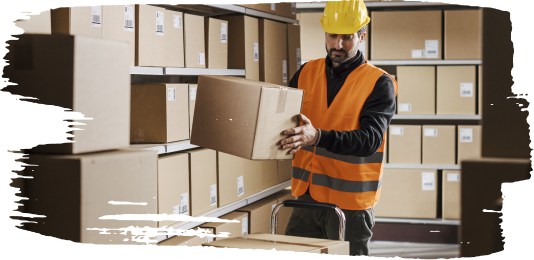 Man in orange safety vest and yellow hard hat organizing cardboard boxes in a warehouse, surrounded by labeled packages on metal shelving, packing orders for EWI Store